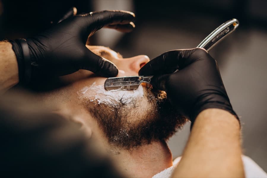 Barbier mit Rasiermesser in seinem Salon